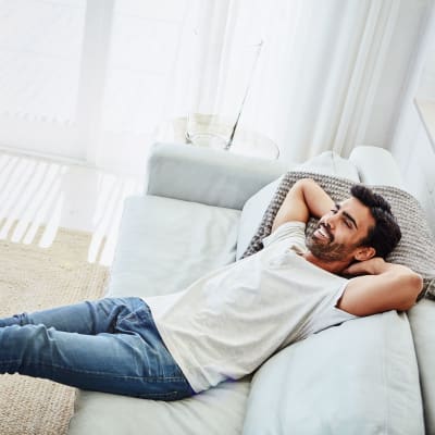 A man relaxing in his living room at Discovery Village in Joint Base Lewis McChord, Washington