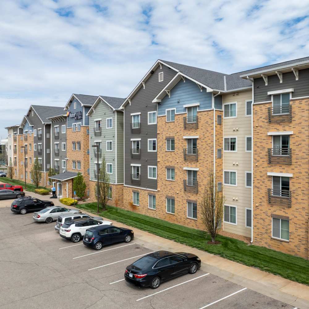 Apartment community exterior with main entrance and parking at WaterWalk Wichita - Downtown in Wichita, Kansas