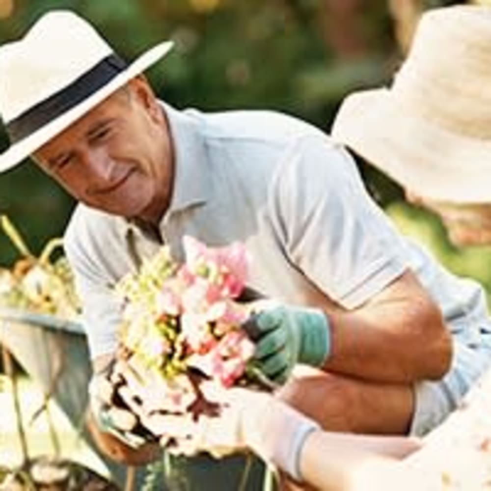 A man and woman planting flowers at The Ridge at Lansing in Lansing, Michigan