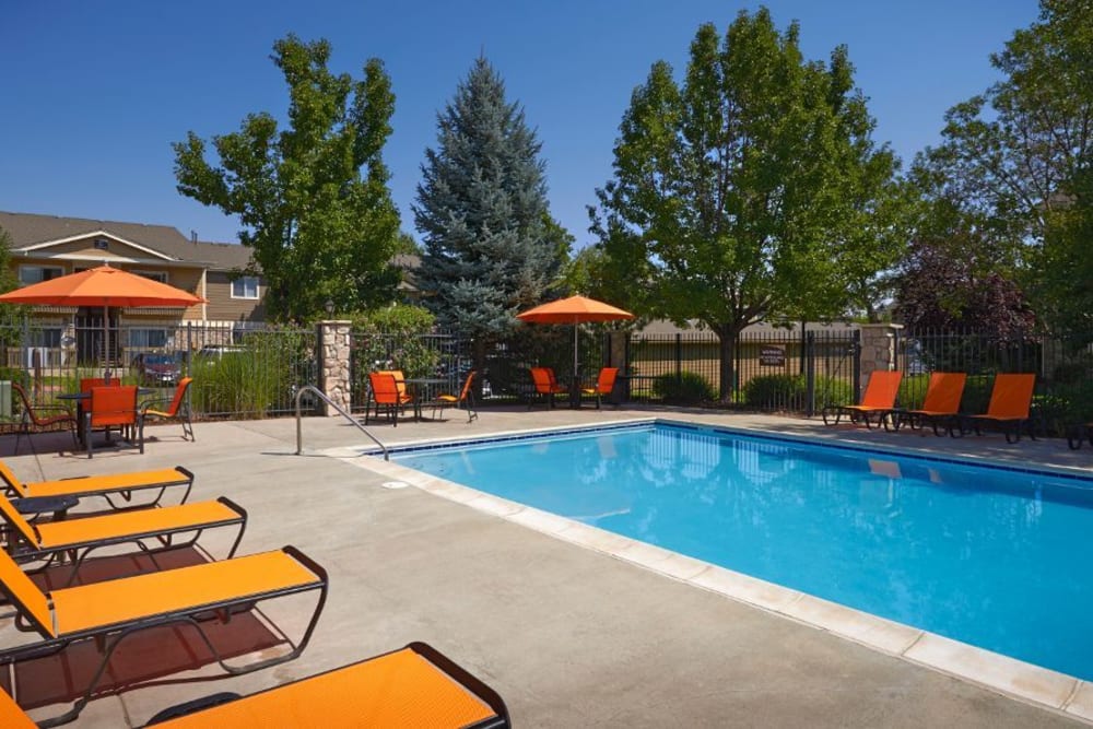 Beautiful resort-style swimming pool with lounge chairs at Crossroads at City Center Apartments in Aurora, Colorado