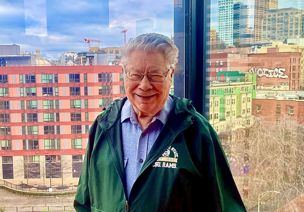 Resident posing with a view out of an upper floor at Truewood by Merrill, First Hill in Seattle, Washington