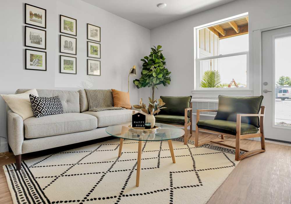 Living room with wood-style flooring, modern furniture, and decorative plants at Tilian Point in Woodburn, Oregon