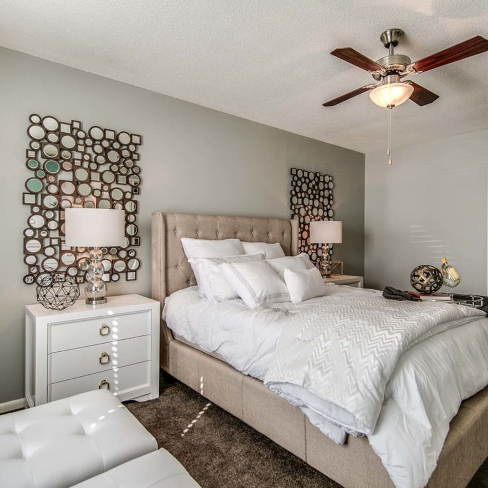 Bedroom with plush carpeting and ceiling fan at London House Apartments in Lenexa, Kansas