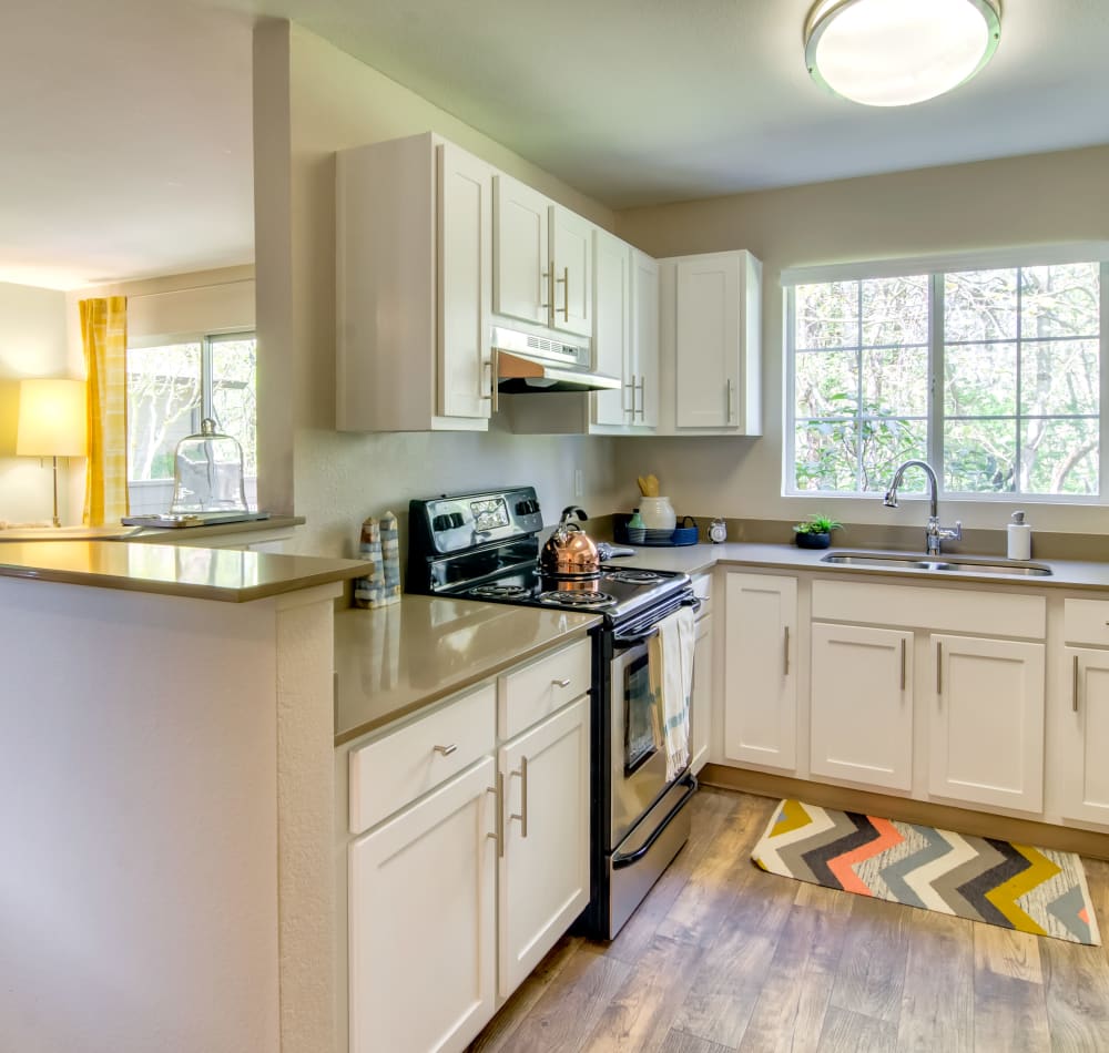 Modern kitchen with quartz countertops looking into the living area of a model home at Sofi at Murrayhill in Beaverton, Oregon