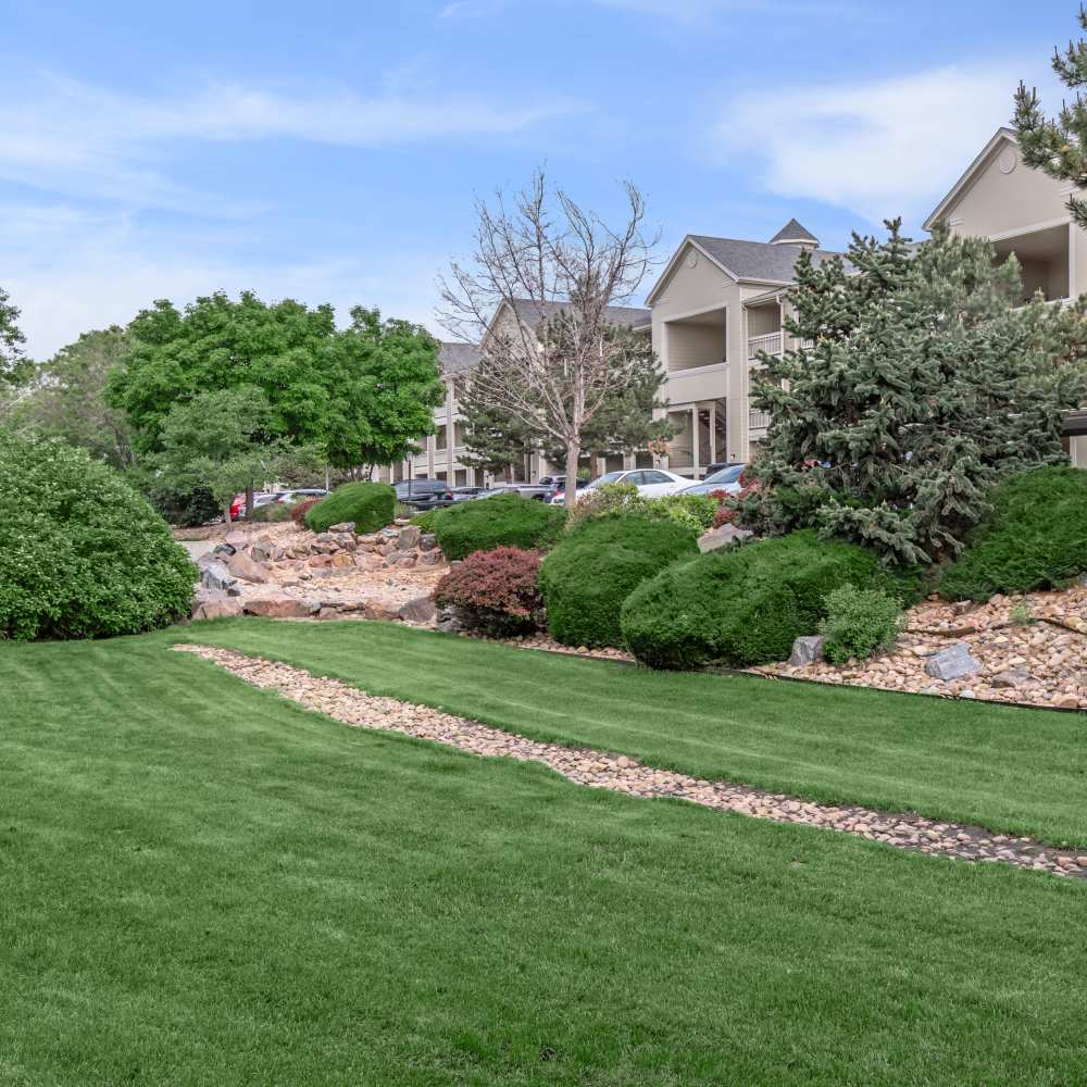Apartment of community with green lawn at One Belmar Place in Lakewood, Colorado