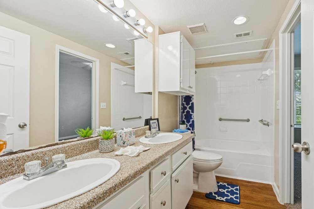 Bathroom with large mirror at Brazoswood Apartments in Clute, Texas