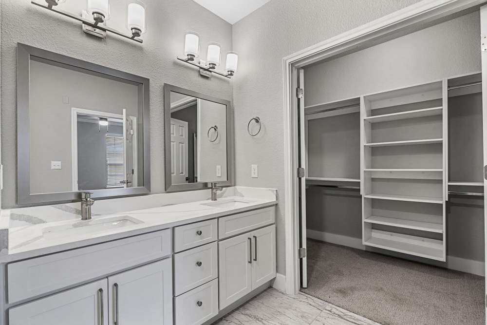 Modern bathroom with vanity light, mirror, sink and attached walk-in closet at Florence in Houston, Texas