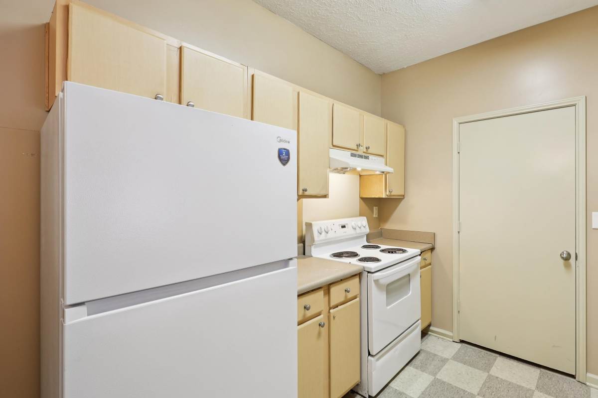 Kitchen with white appliance and storage space at Camden Park in Canton, Mississippi