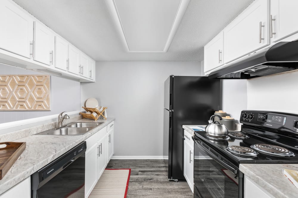 Kitchen with modern white cabinets and black appliances at Astoria Park Apartment Homes in Indianapolis, Indiana