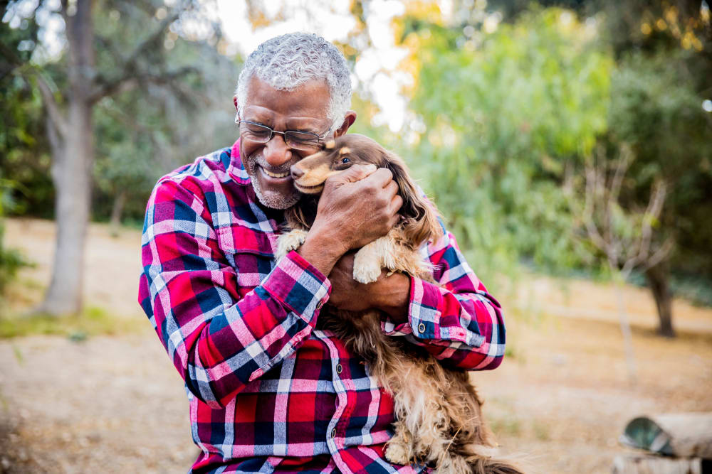 Resident hugging their small dog outside near Meridian Senior Living in Bethesda, Maryland