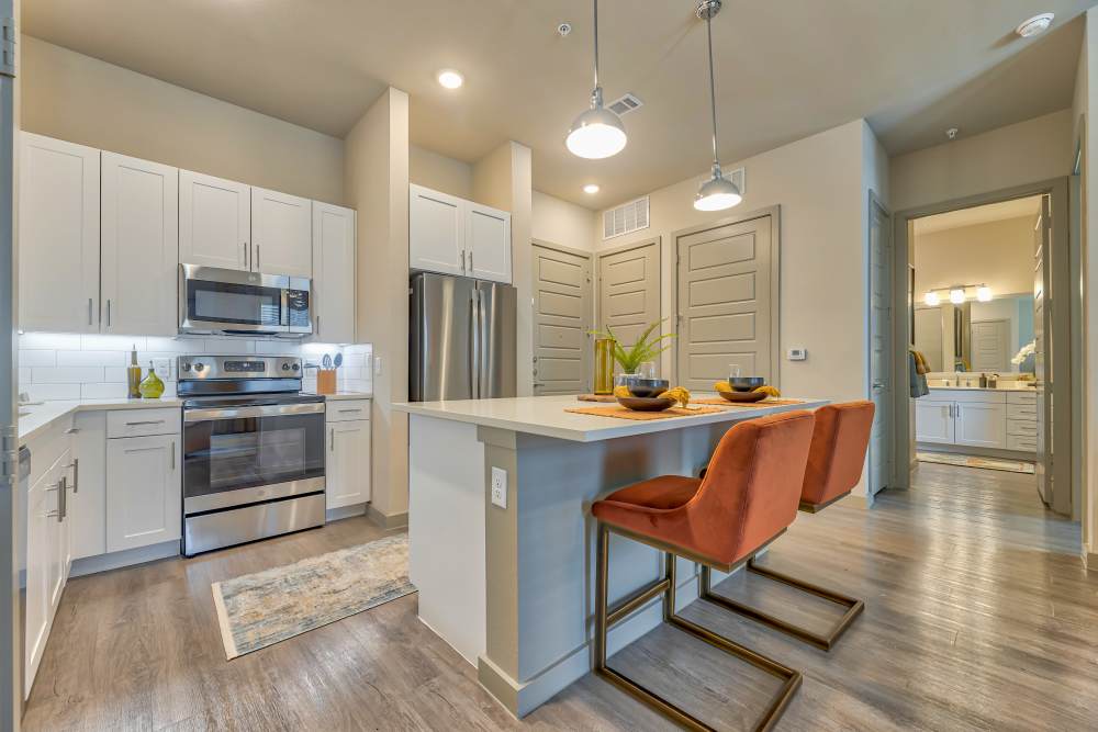 Kitchen with range and wooden cabinets at Ennova Highlands in Arlington, Texas