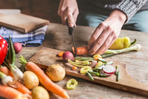 Resident chopping fresh vegetables from the market near The Brunswick in New Brunswick, New Jersey