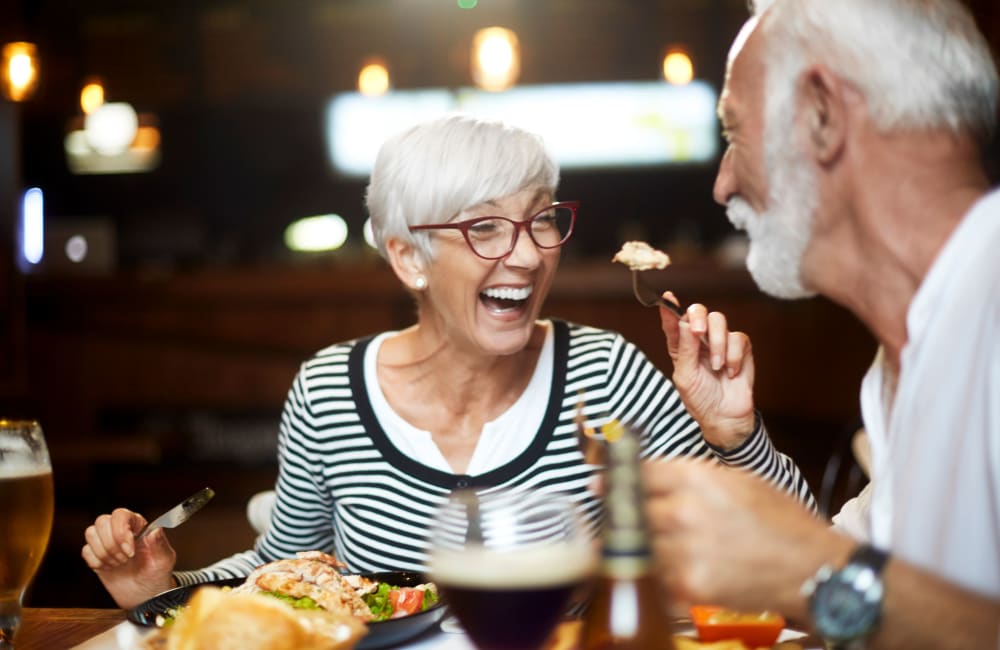 Couple chatting over dinner at Campus Commons Senior Living in Sacramento, California