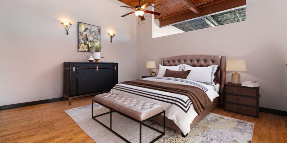 Cozy bedroom with a ceiling fan at The Lofts at Swift Mill in Columbus, Georgia