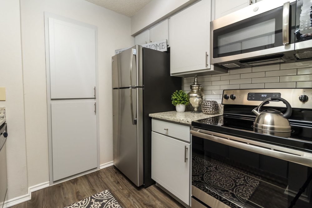 Kitchen with beautiful dark wood cabinets at The Logan in Bedford, Texas
