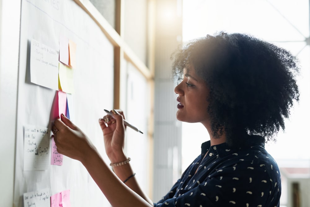 Professional woman adding a note to a whiteboard at A-American Self Storage