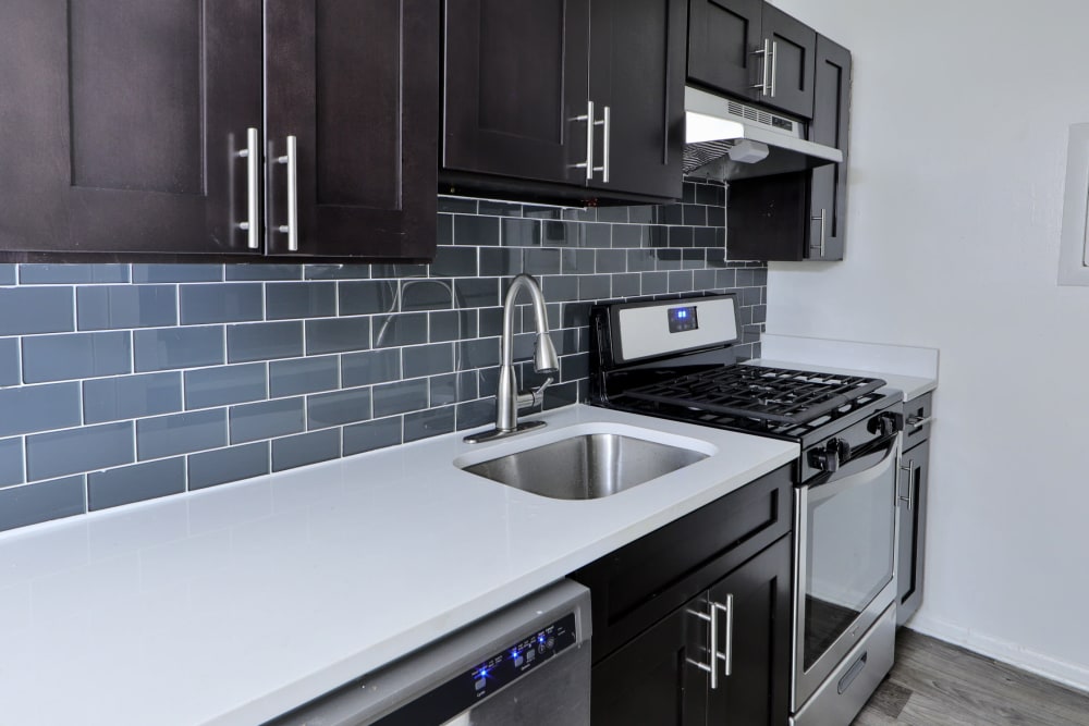 Kitchen with a tile backsplash and espresso cabinetry at Bennington Crossings Apartment Homes in Alexandria, Virginia