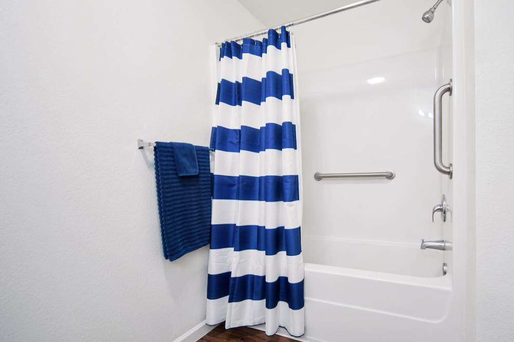 Modern bathroom with stylish blue and white shower curtain at Villas At Meadow Springs in Ankeny, Iowa