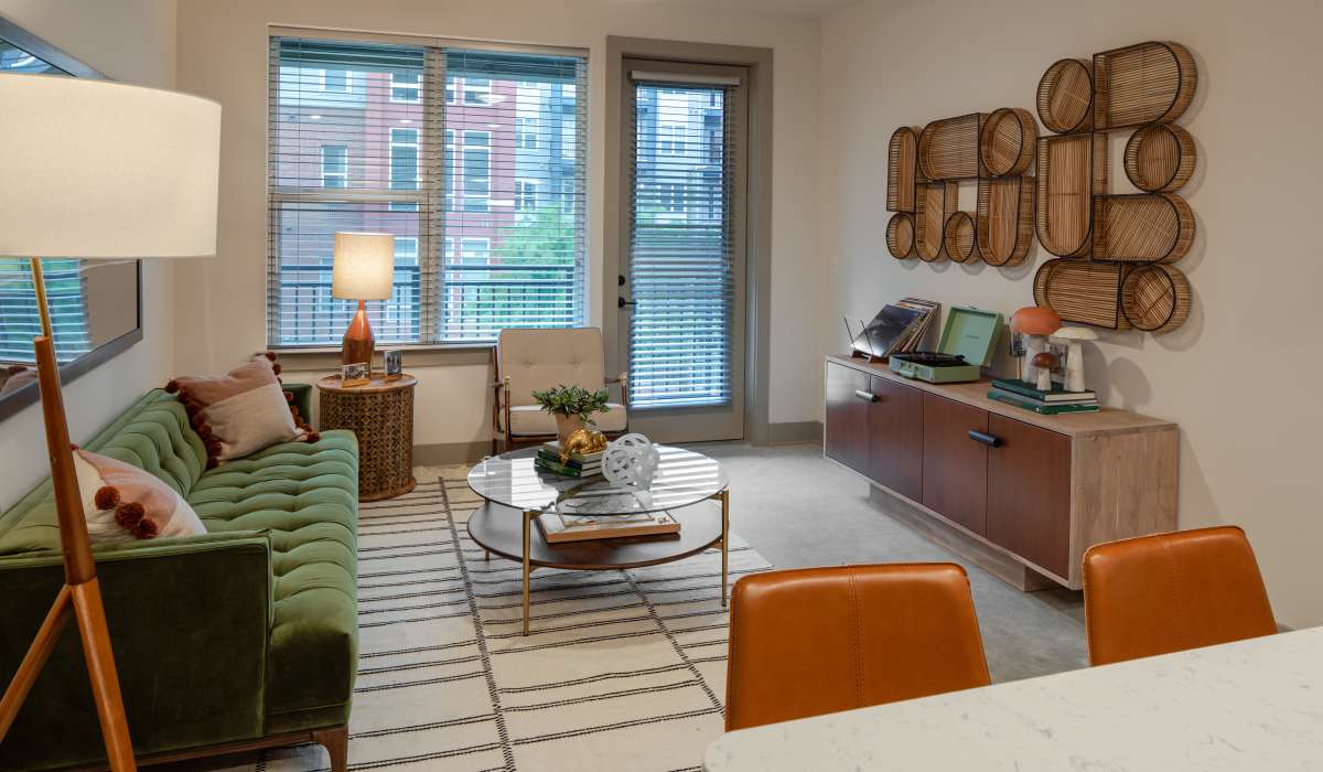 Living room with a door out to a private balcony at Venable Durham Apartments in Durham, North Carolina