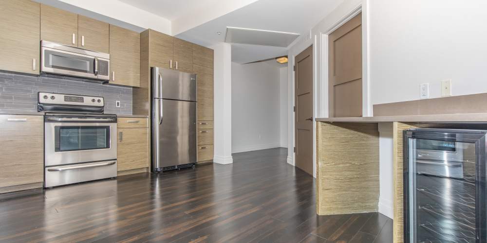 Kitchen with built-in wine fridge, wooden cabinets and stainless-steel appliances at The View at Wash Park in Denver,Colorado