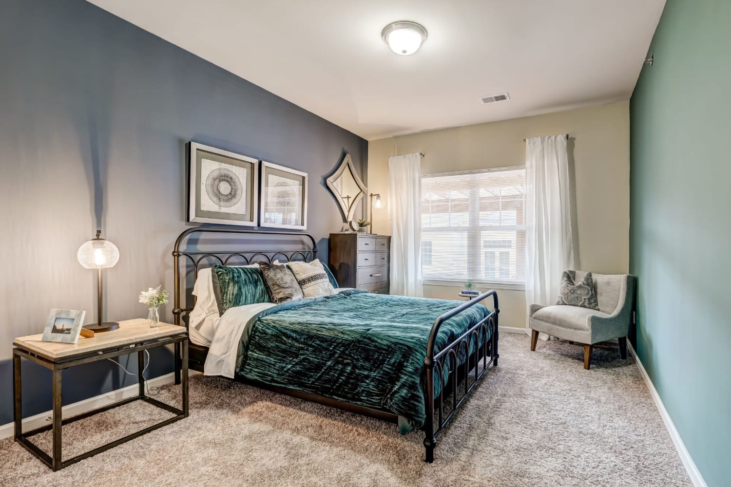 Large master bedroom with plush carpeting and an accent wall at Torrente Apartment Homes in Upper St Clair, Pennsylvania