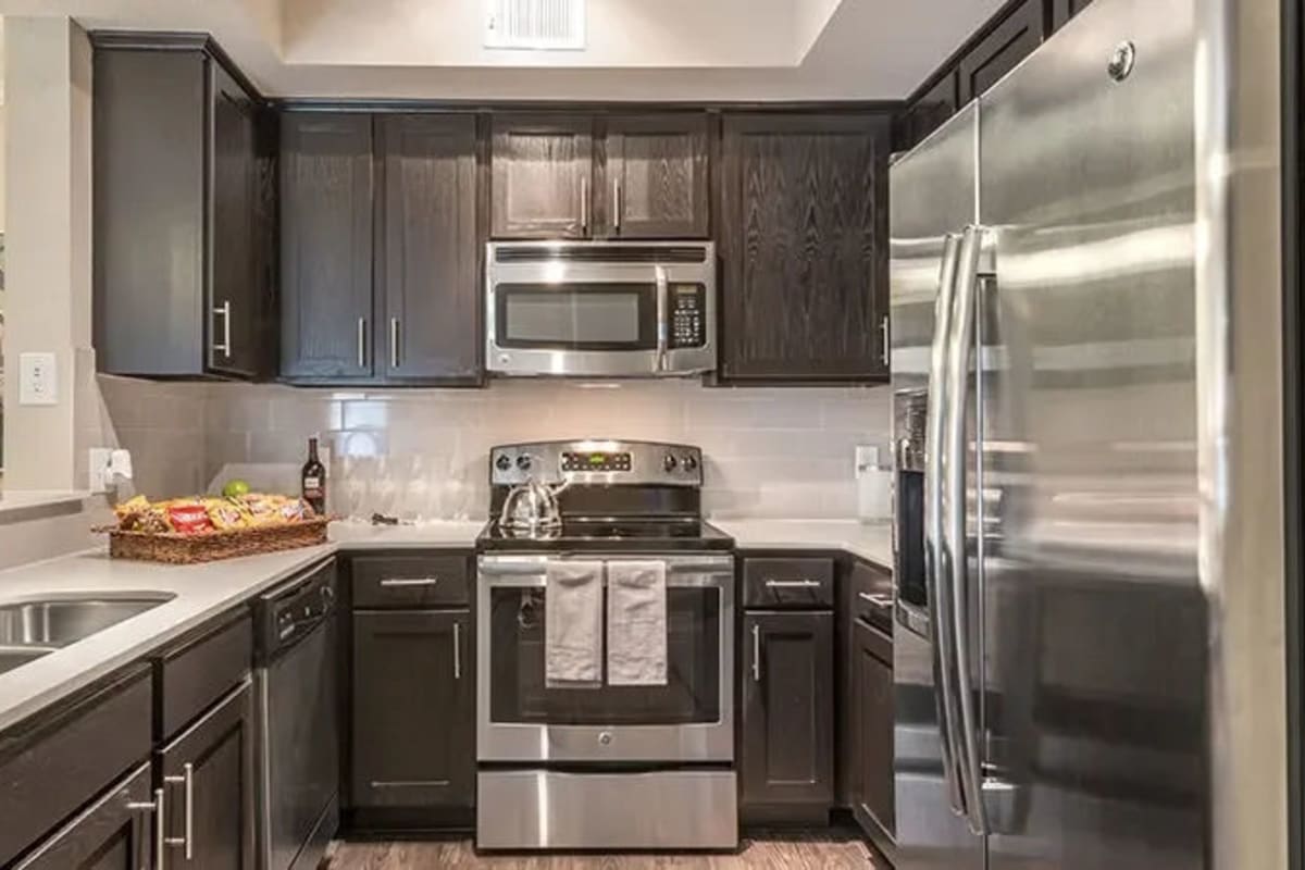 Dark cabinets and stainless-steel appliances in a kitchen at Reserve at Stonebridge Ranch in McKinney, Texas