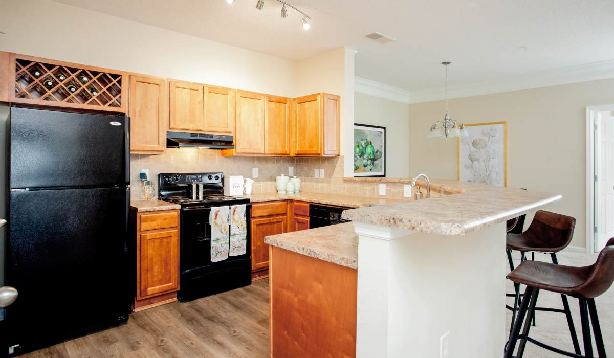 Apartment kitchen with stainless-steel appliances and wooden cabinetry at Madison Park in Madison, Alabama