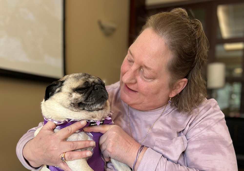 Resident with a puppy at Merrill Gardens at Tacoma in Tacoma, Washington