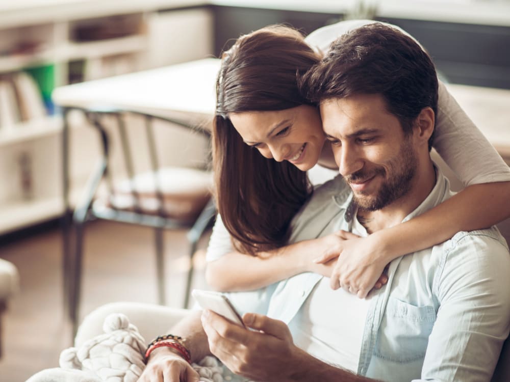 Resident couple connecting with us on social media on a mobile device in their new home at Sofi at Topanga Canyon in Chatsworth, California