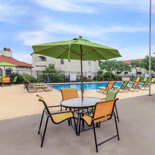 Covered tables and chairs by the pool at Villas de Toscana in San Antonio, Texas