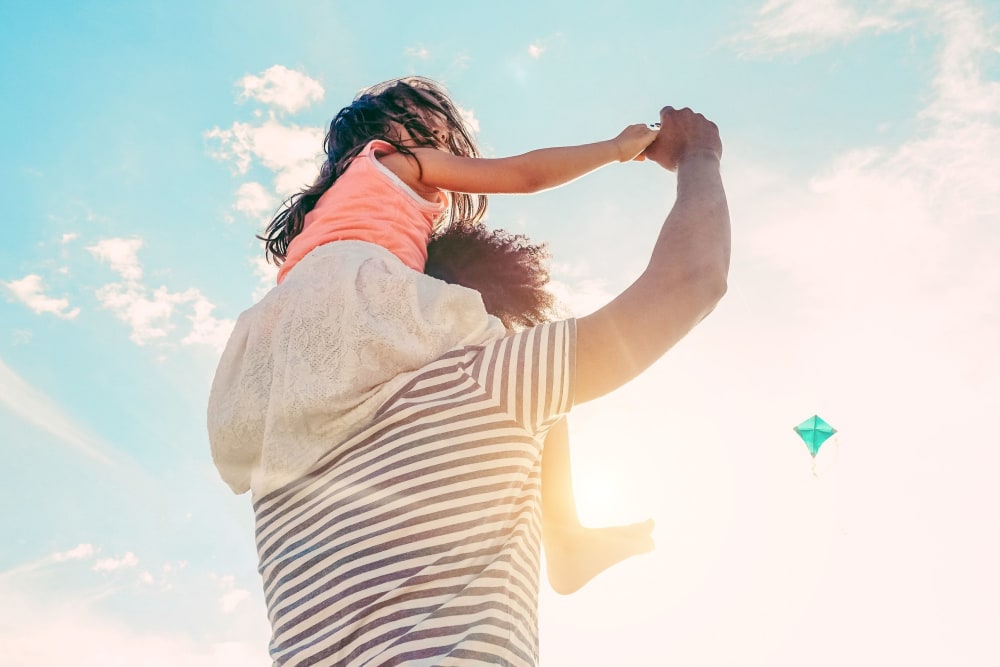 A resident carrying a child on his shoulders at Villa Bella in Euless, Texas