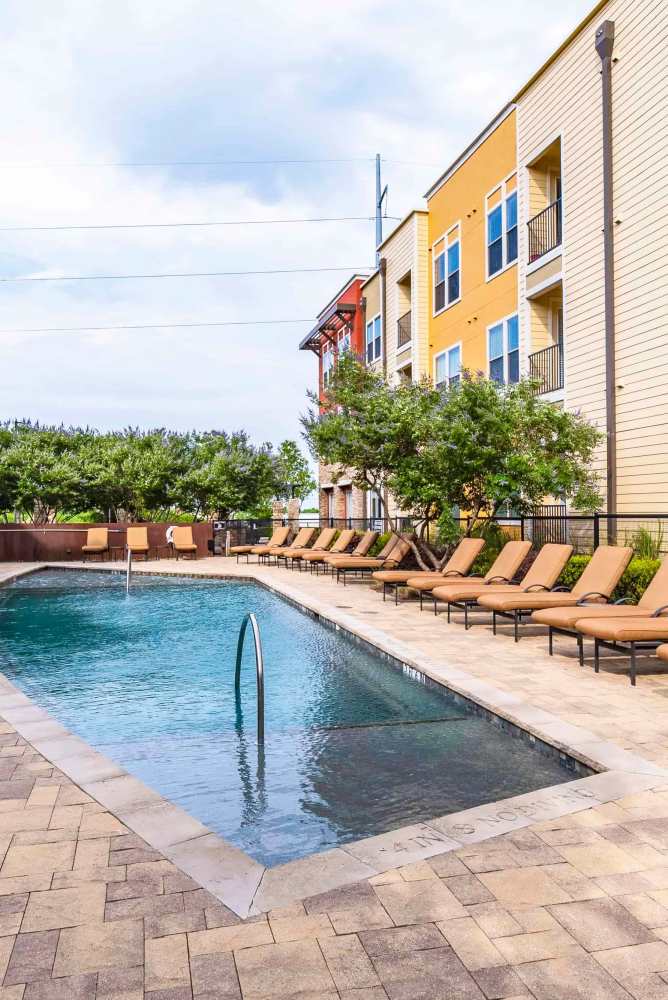 Community pool with sun loungers by the pool at Grapevine Station in Grapevine,Texas