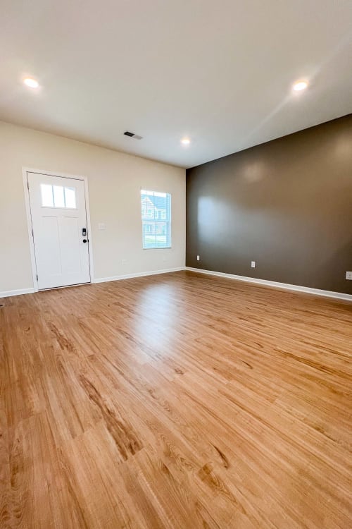 Spacious living area with wood-style flooring at Parallel 36 at Legacy in Opelika, Alabama