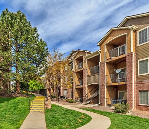 Exterior building shot, grass and trees at Arapahoe Club Apartments in Denver