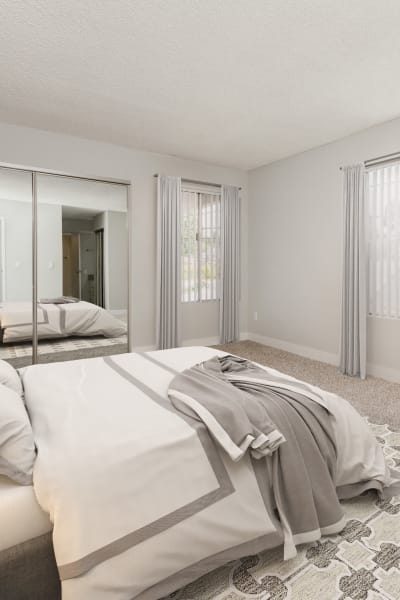 Model bedroom with white bedspread and two lamps at Los Feliz Village, Los Angeles, California