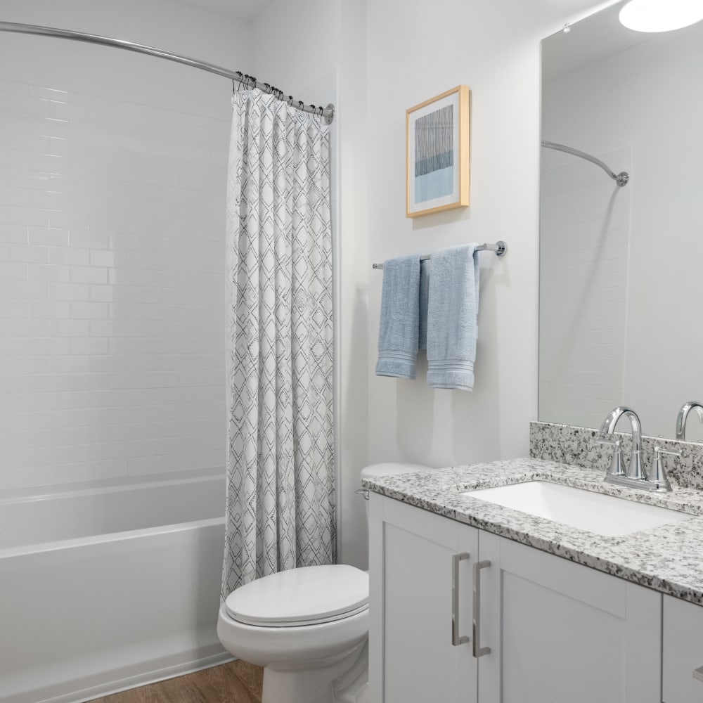 Model bathroom with granite countertops at The Archer In Acworth in Acworth, Georgia