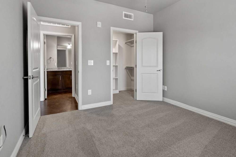 Model apartment with carpet flooring and walk-in closets at Pine Creek in Paris, Texas