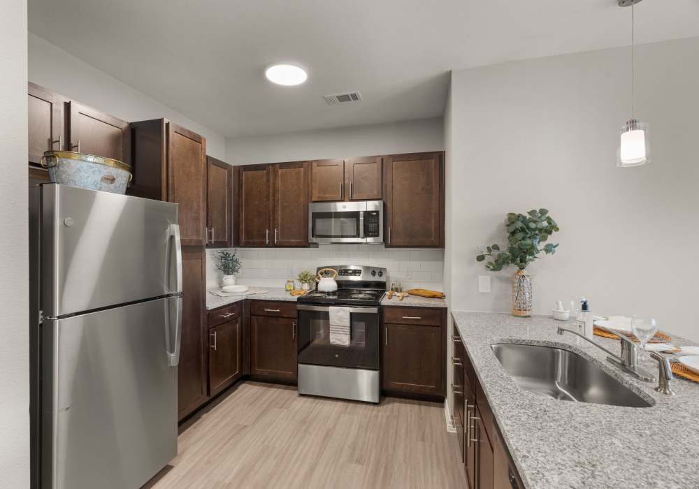 Kitchen with black appliances in a modern apartment home at Walnut Springs in Seguin, Texas