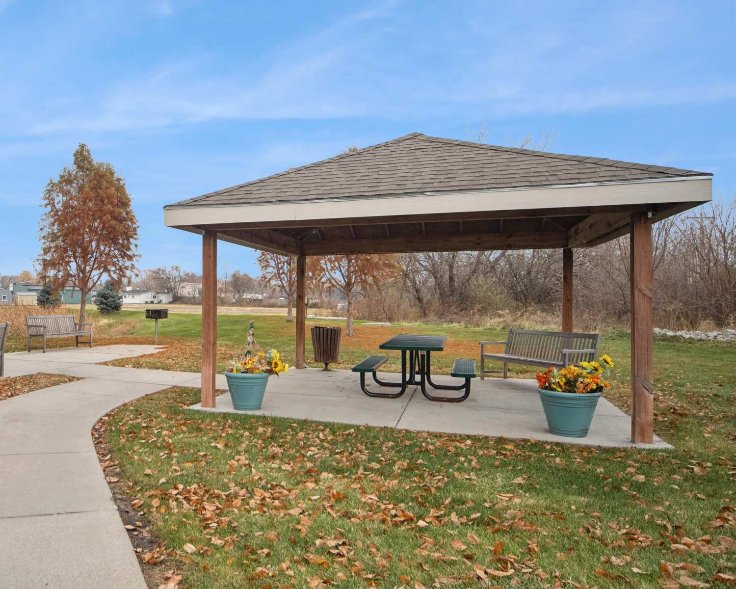 Charming pavilion surrounded by lush greenery and colorful flowers at Villas At Meadow Springs in Ankeny, Iowa 