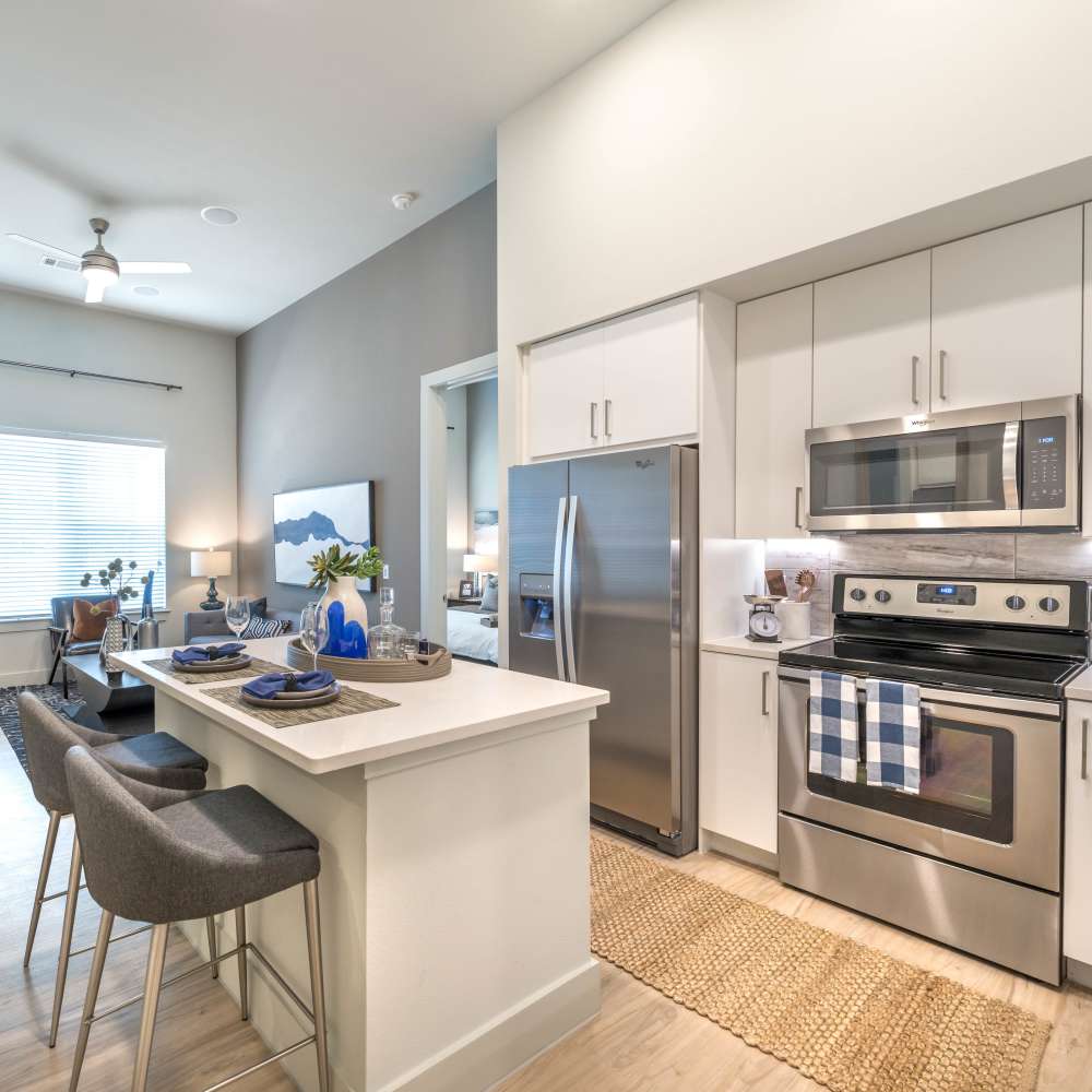 Breakfast bar and stainless steel appliance in the modern kitchen at Hall Street Flats in Dallas, Texas