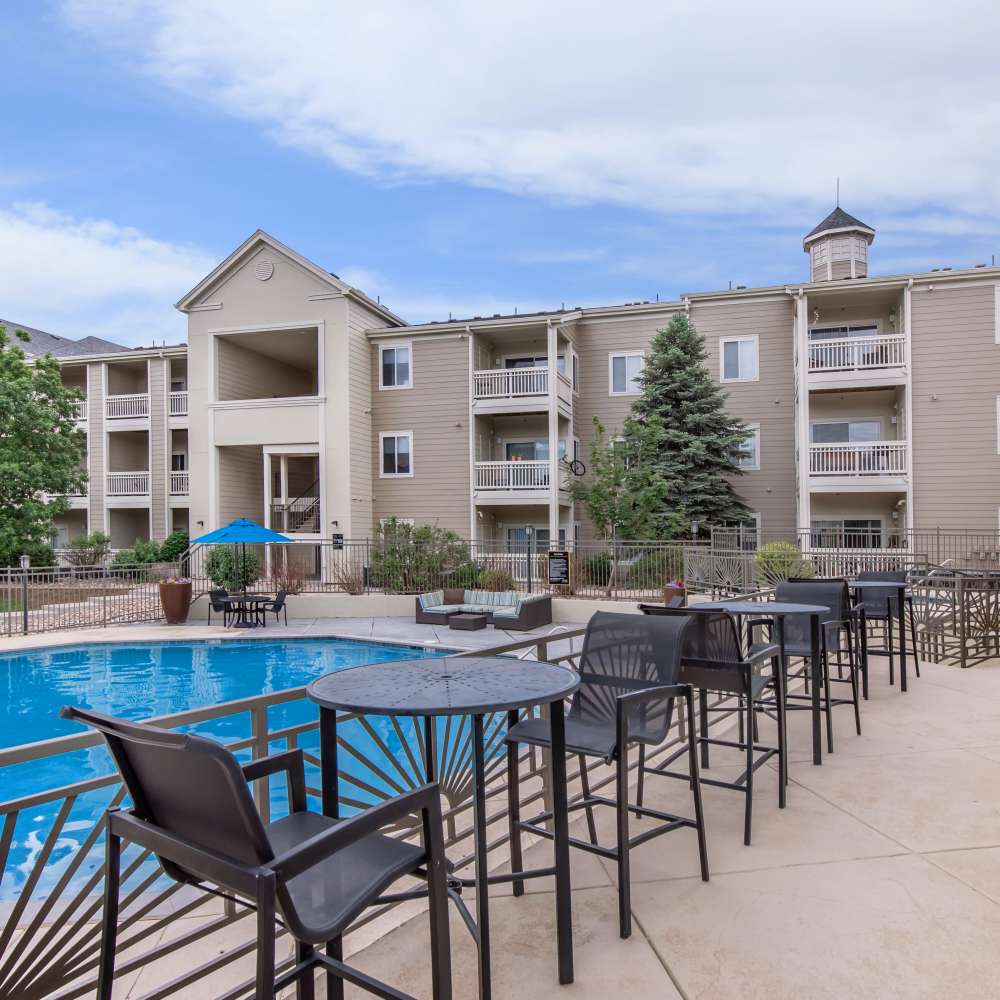Seating area along swimming pool at One Belmar Place in Lakewood, Colorado
