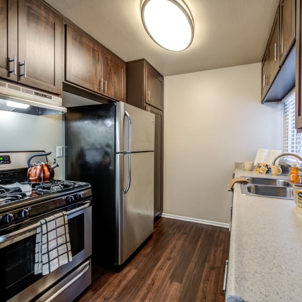 Brown renovated kitchen cabinets with stainless steel appliances at Kendallwood Apartments in Whittier,CA