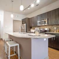 Apartment kitchen with island counter at Grapevine Station in Grapevine, Texas
