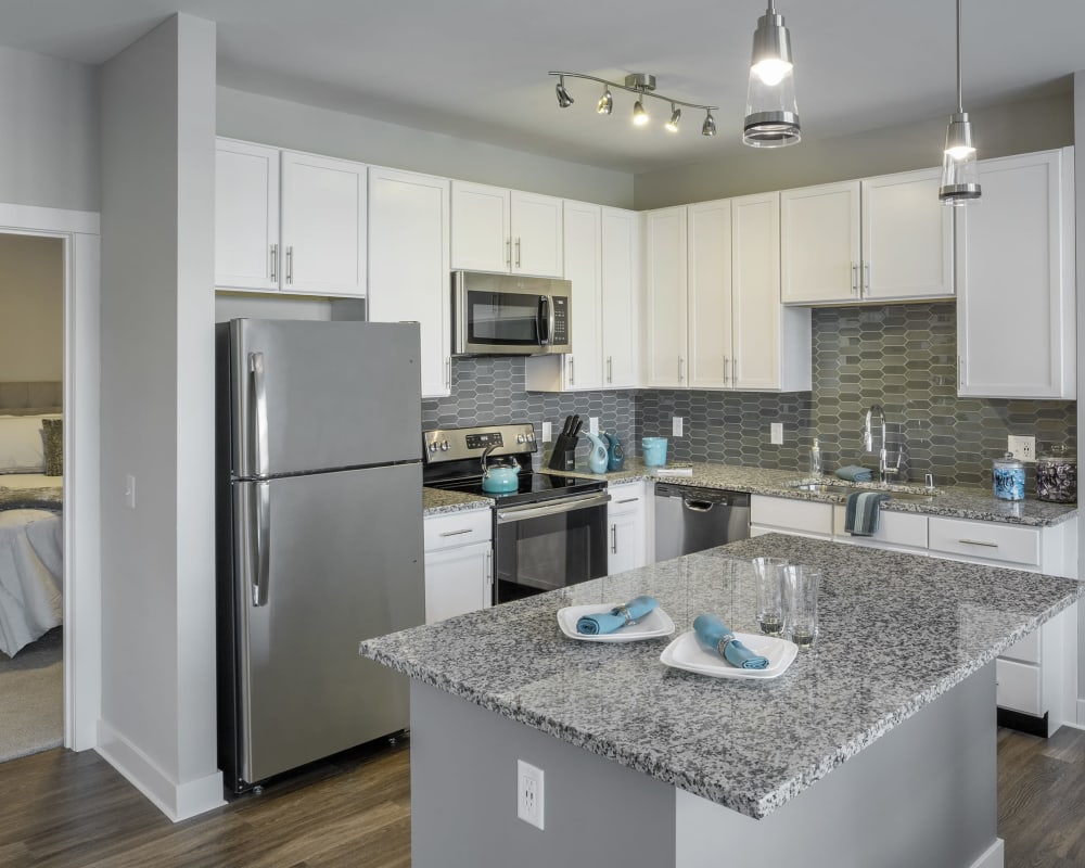 Spacious model kitchen complete with granite countertops, island, and stainless steel appliances at The Residences at Crosstree in Freeport, Maine