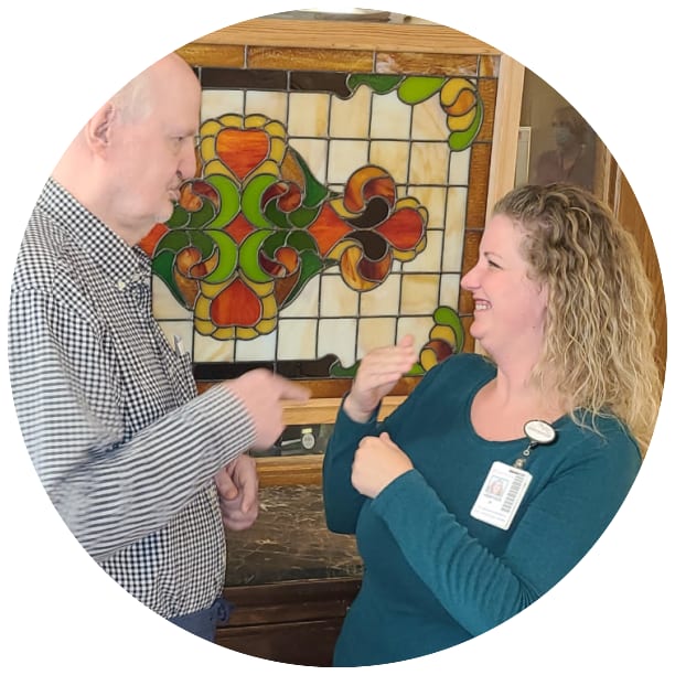 Resident and a guest signing to each other at Ebenezer Senior Living in Edina, Minnesota