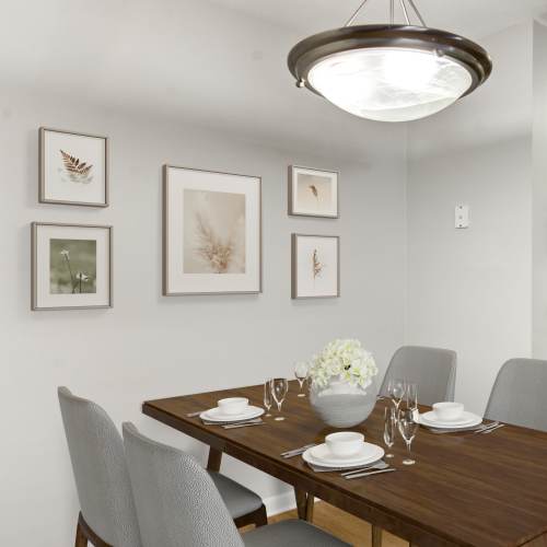 Dining room with kitchen table and chandelier light above at Stony Brook Village in Hyde Park, Massachusetts