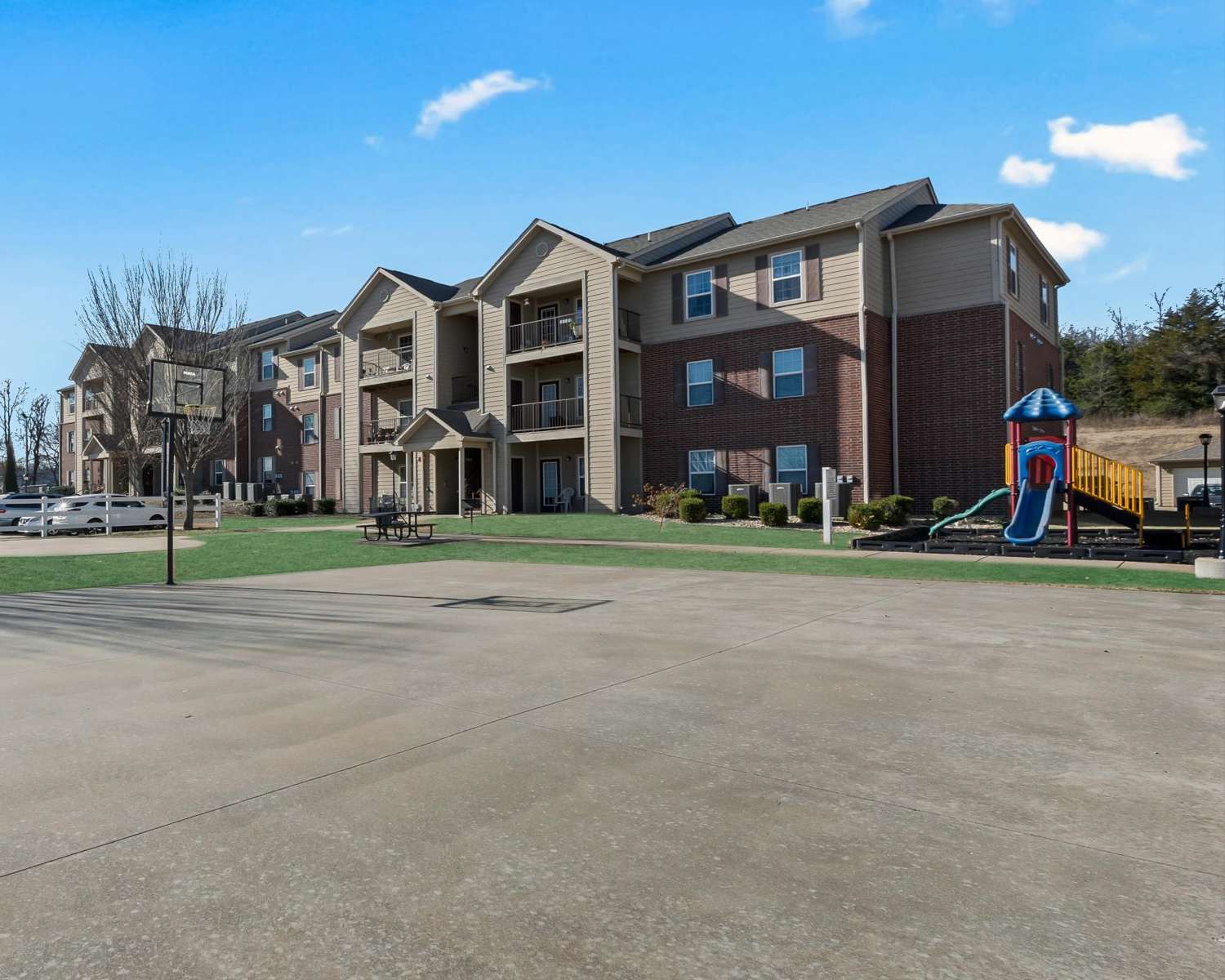Modern apartment complex with playground and basketball court at Wickham Gardens in Sapulpa, Oklahoma