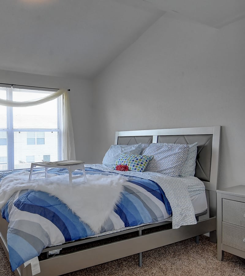 Master bedroom with bed and large windows at Mariner's Watch in Norfolk, Virginia