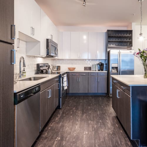 Apartment kitchen with wood-style flooring and stainless-steel appliances at Station R Apartments in Atlanta, Georgia