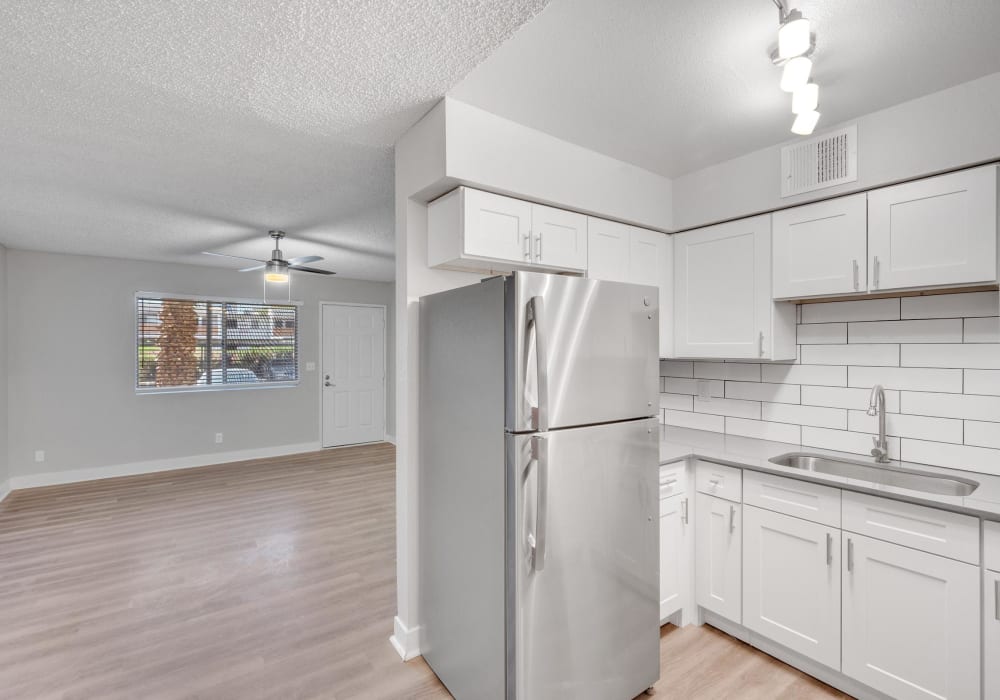 Kitchen with white cabinetry and wood-style flooring at Tides on Wynn in Las Vegas, Nevada